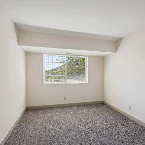 a room with a window and a carpeted floor.