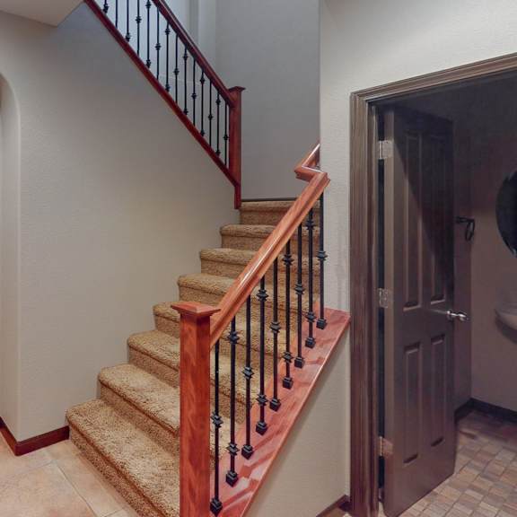 a staircase with a red handrail and wooden steps.