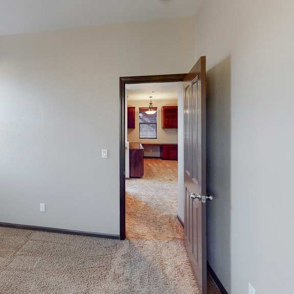 a room with a carpeted floor and a doorway leading to another room.