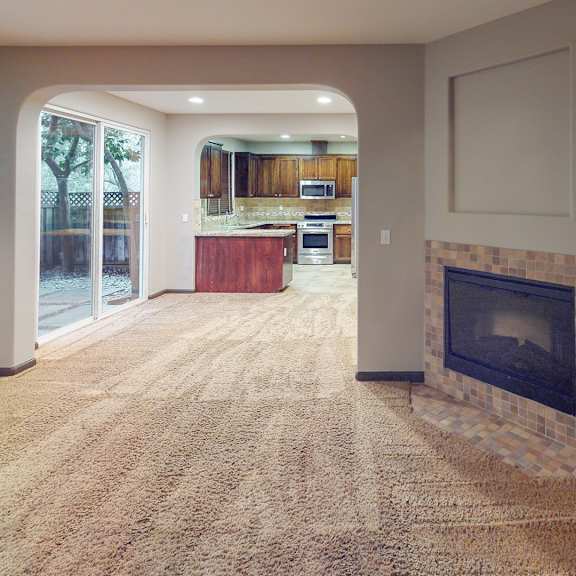 a living room with a fireplace and a carpet.