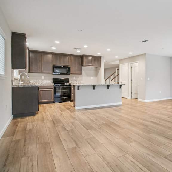 a spacious kitchen with wooden floors and modern appliances.