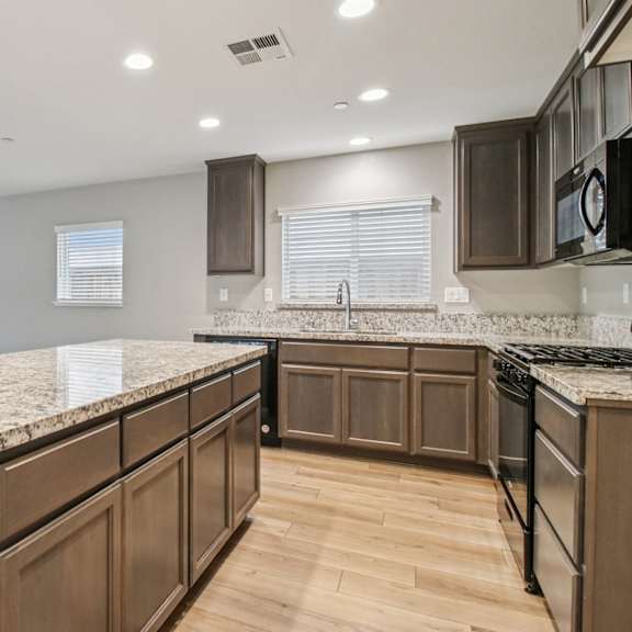 a kitchen with brown cabinets and a granite countertop.