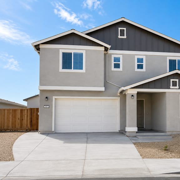 a two-story house with a garage and a driveway.