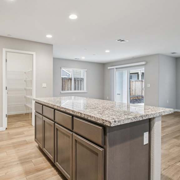 a kitchen with a granite countertop and wooden floors.