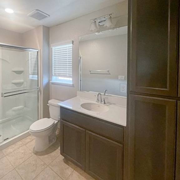 a bathroom with a toilet, sink, and shower.
