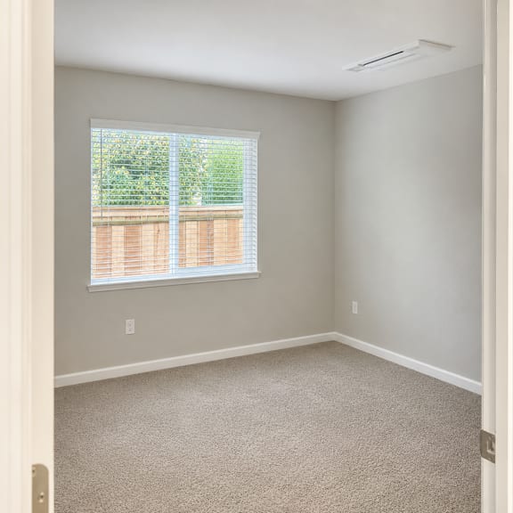 a room with a window and carpeted floor.