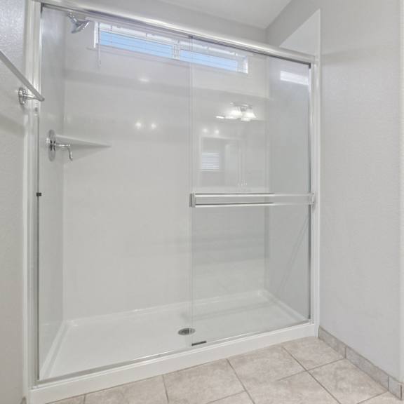 a white bathroom with a glass shower stall.