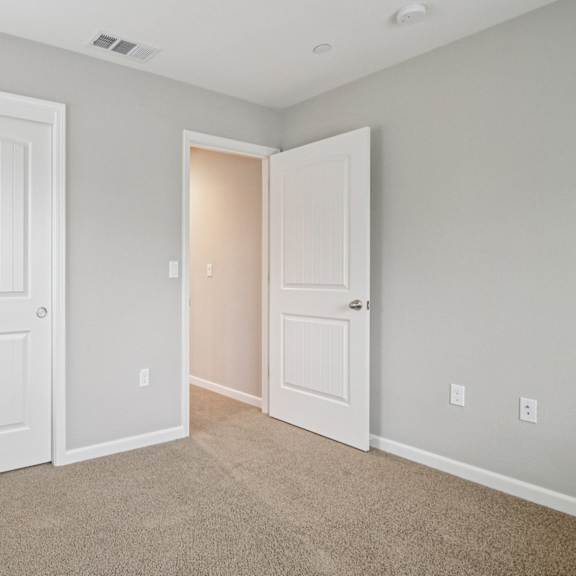 a room with two white doors and a carpeted floor.