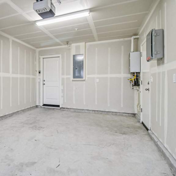 a room with white walls and a door in the middle.