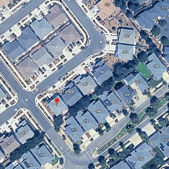 a satellite image of a street with a red pin marking a specific location.