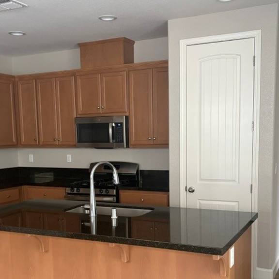 a kitchen with wooden cabinets and a black countertop.