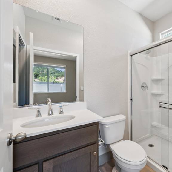 a white bathroom with a shower at montessa apartments, california, 95687