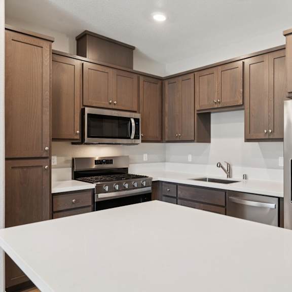 a kitchen with brown cabinets at montessa apartments, california