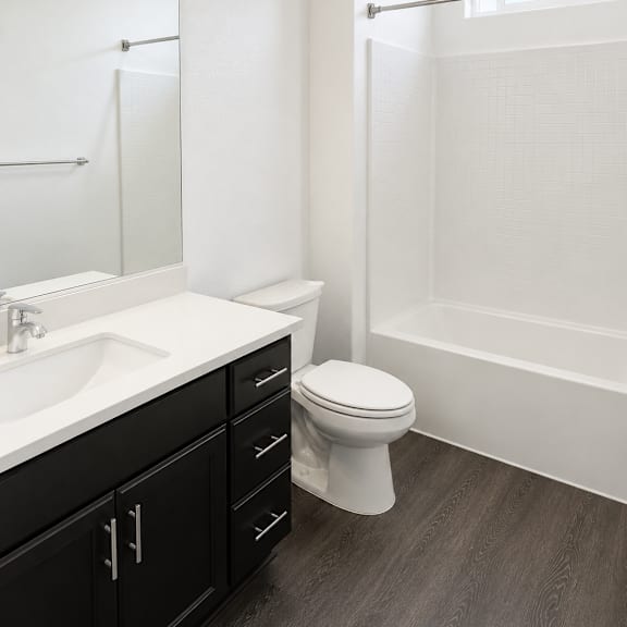 a white bathroom with a toilet, sink, and bathtub.