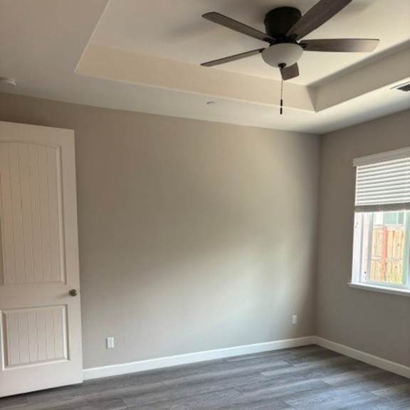 a room with a ceiling fan and a door.
