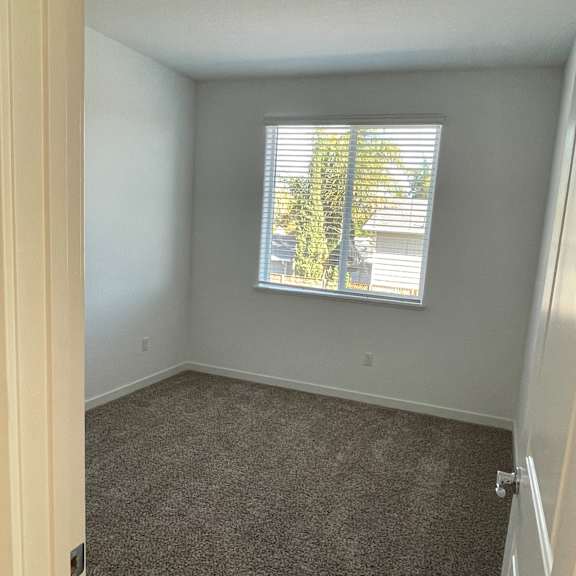 a room with a window and a grey wall.