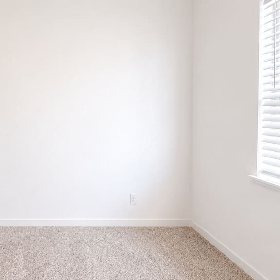 a room with a carpeted floor and a door on the left.