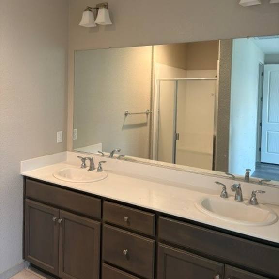 a bathroom with a white sink and brown cabinets.
