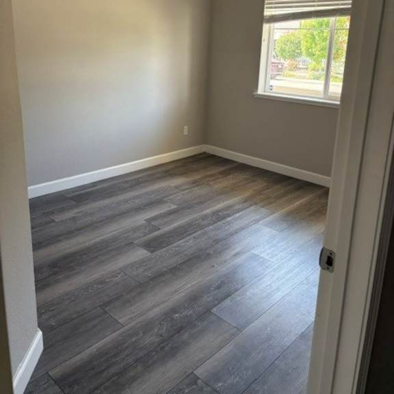 a room with a window and wooden flooring.
