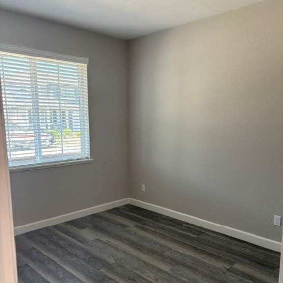 a room with a window and wooden flooring.