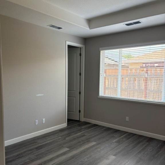 a room with a grey floor and a window with blinds.