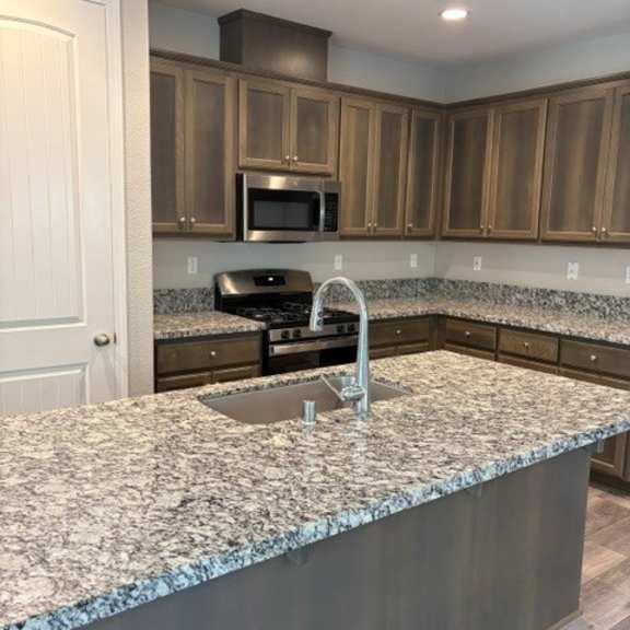 a kitchen with granite countertops and wooden cabinets.