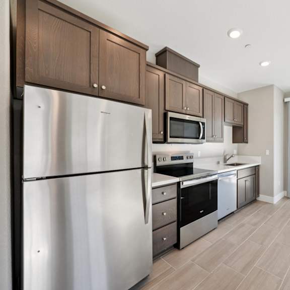 a kitchen with a stainless steel refrigerator at montessa apartments, california