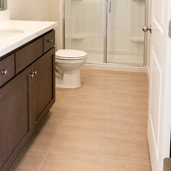 a bathroom with a toilet, sink, and shower.