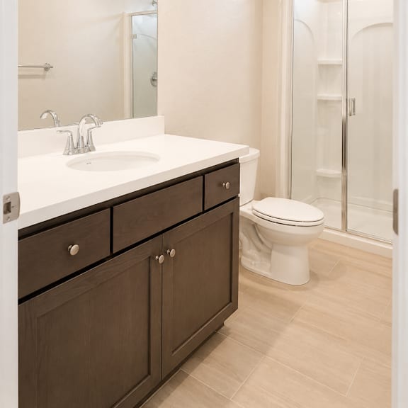 a white sink with a silver faucet and a white toilet in a bathroom.
