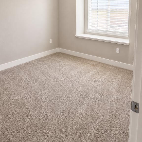 a room with a window and carpeted floor.