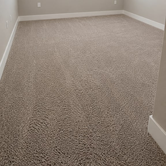a room with a carpeted floor and a window with blinds.