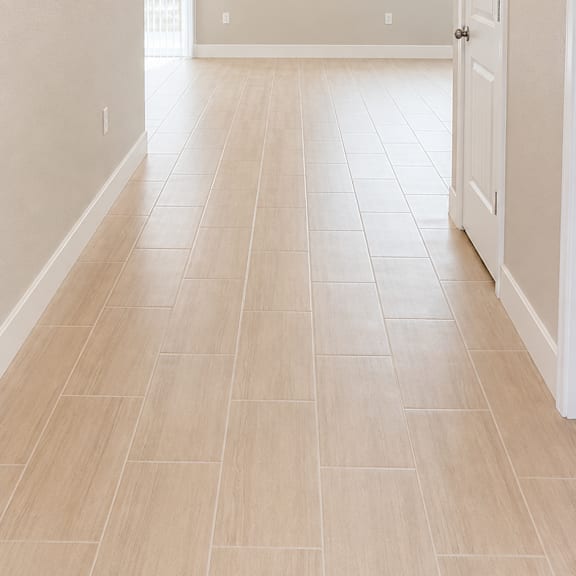 a long hallway with a white door at the end.