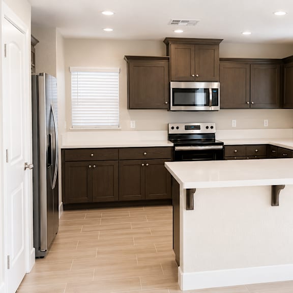 a kitchen with brown cabinets and a black countertop.