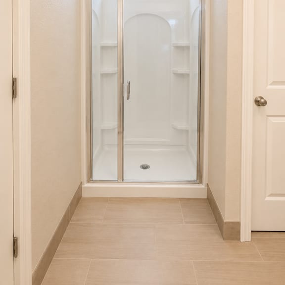 a white bathroom with a walk in shower.