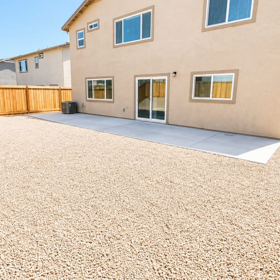 a house with a brown fence and tan siding.
