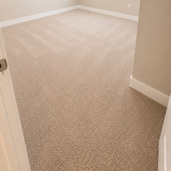 a room with a carpeted floor and a window with blinds.