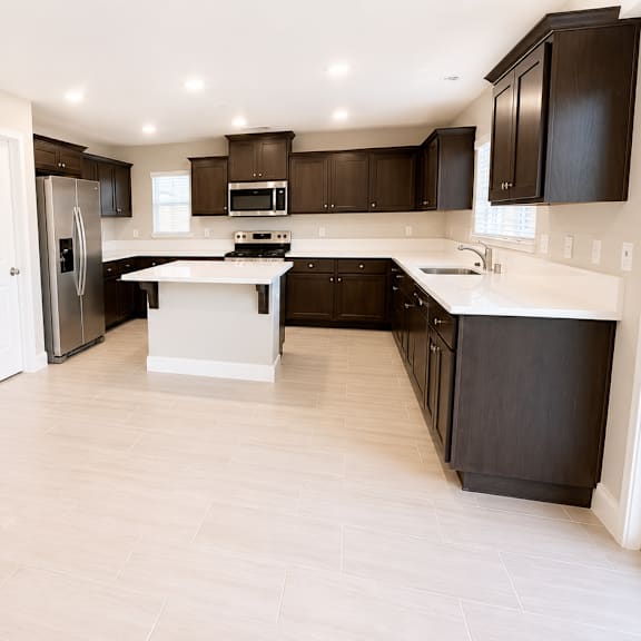 a kitchen with black cabinets and a white island.