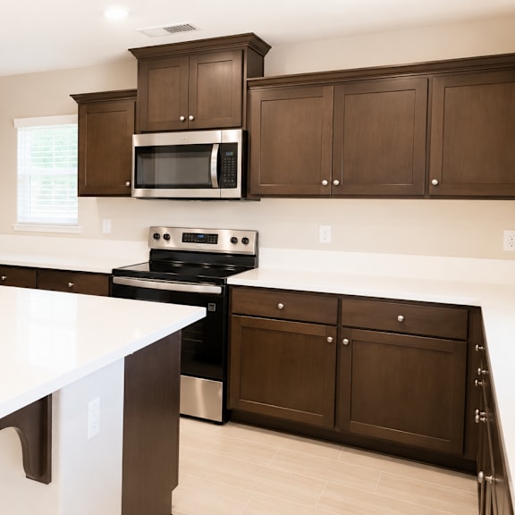 a kitchen with a white island and brown cabinets.