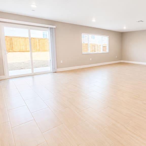 a spacious room with wooden flooring and a large window.