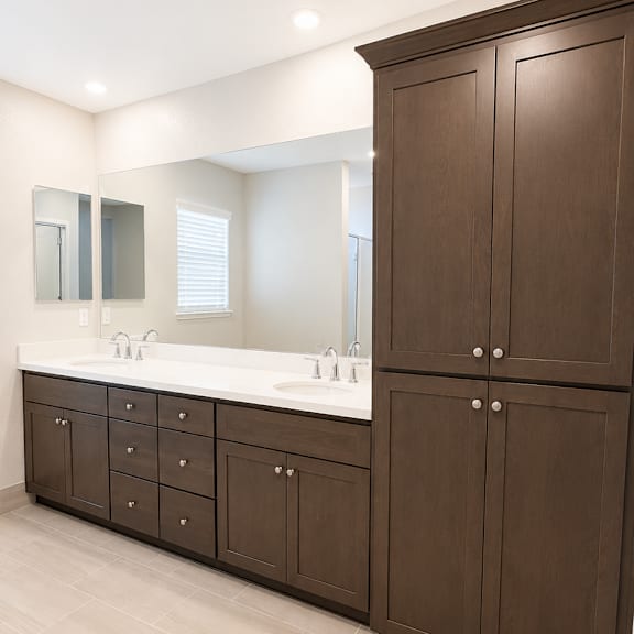 a bathroom with brown cabinets and a white counter.