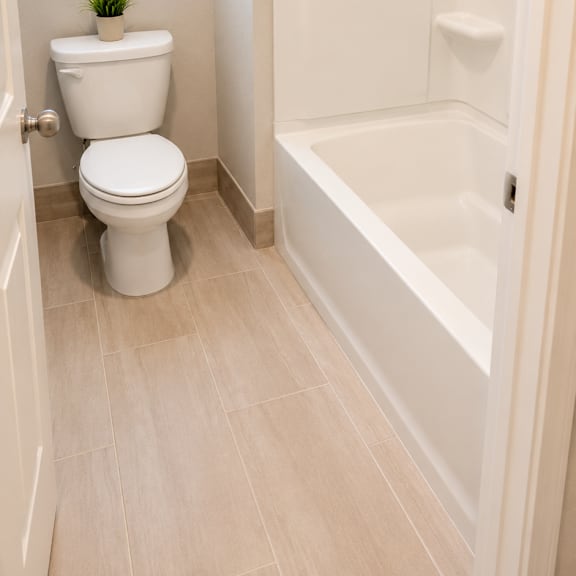 a white toilet sits next to a white bathtub in a bathroom.