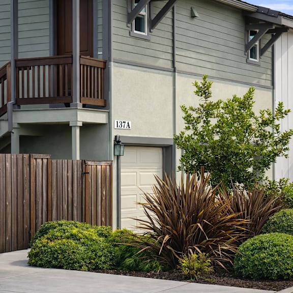 a two-story house with a balcony and a fence.
