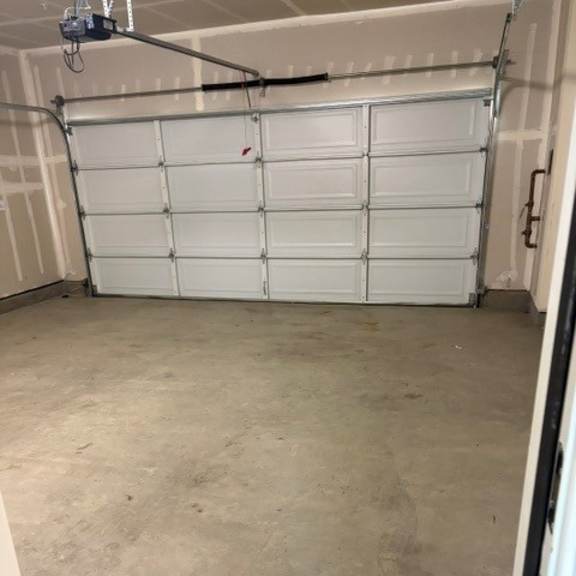 a garage with a white door and a concrete floor.