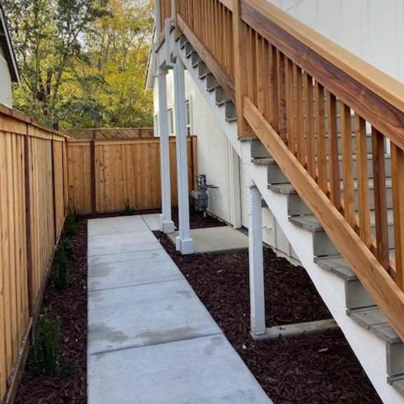 a wooden staircase with a white railing and a white wall on the side.