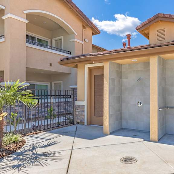 a walk in shower in front of a house with a patio at heritage landing apartments, chico, ca