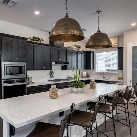 a kitchen with stainless steel appliances and a large island with chairs at heritage landing apartments, california, 95973