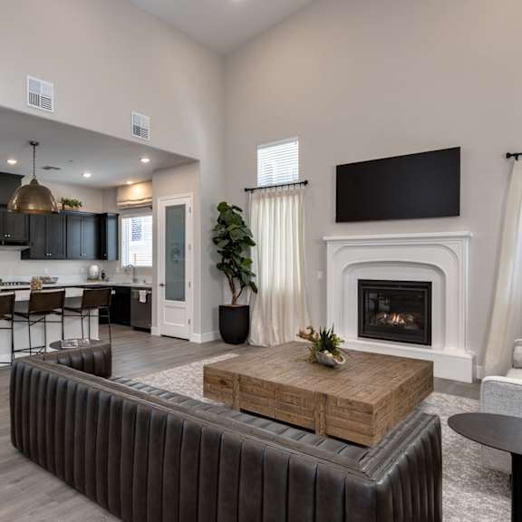 a living room with a fireplace and a kitchen with a table and chairs at heritage landing apartments, chico, 95973