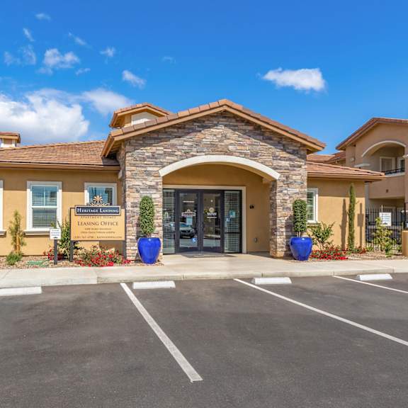 the entrance to a building with a parking lot at heritage landing apartments, chico