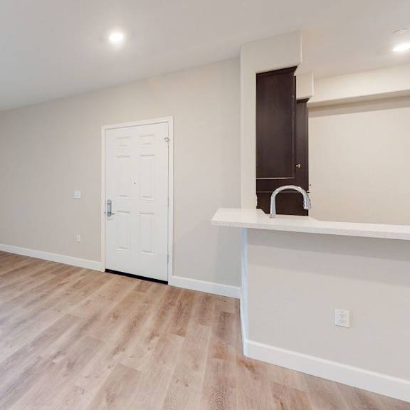 the living room and kitchen of a new home with wood flooring at heritage landing apartments, california, 95973