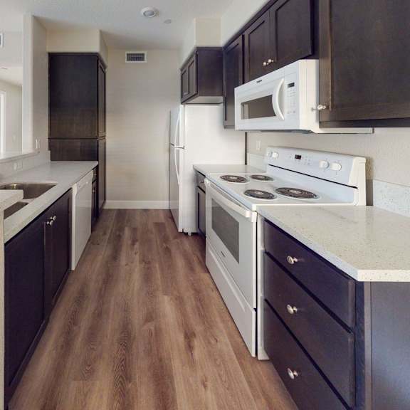 a kitchen with white appliances and black cabinets at heritage landing apartments, chico, ca, 95973